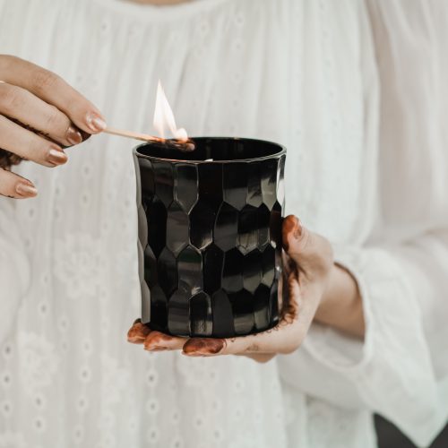 AND collection lighting the full size candle in hand