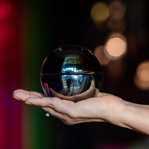 Iridescent black dome candle in hand