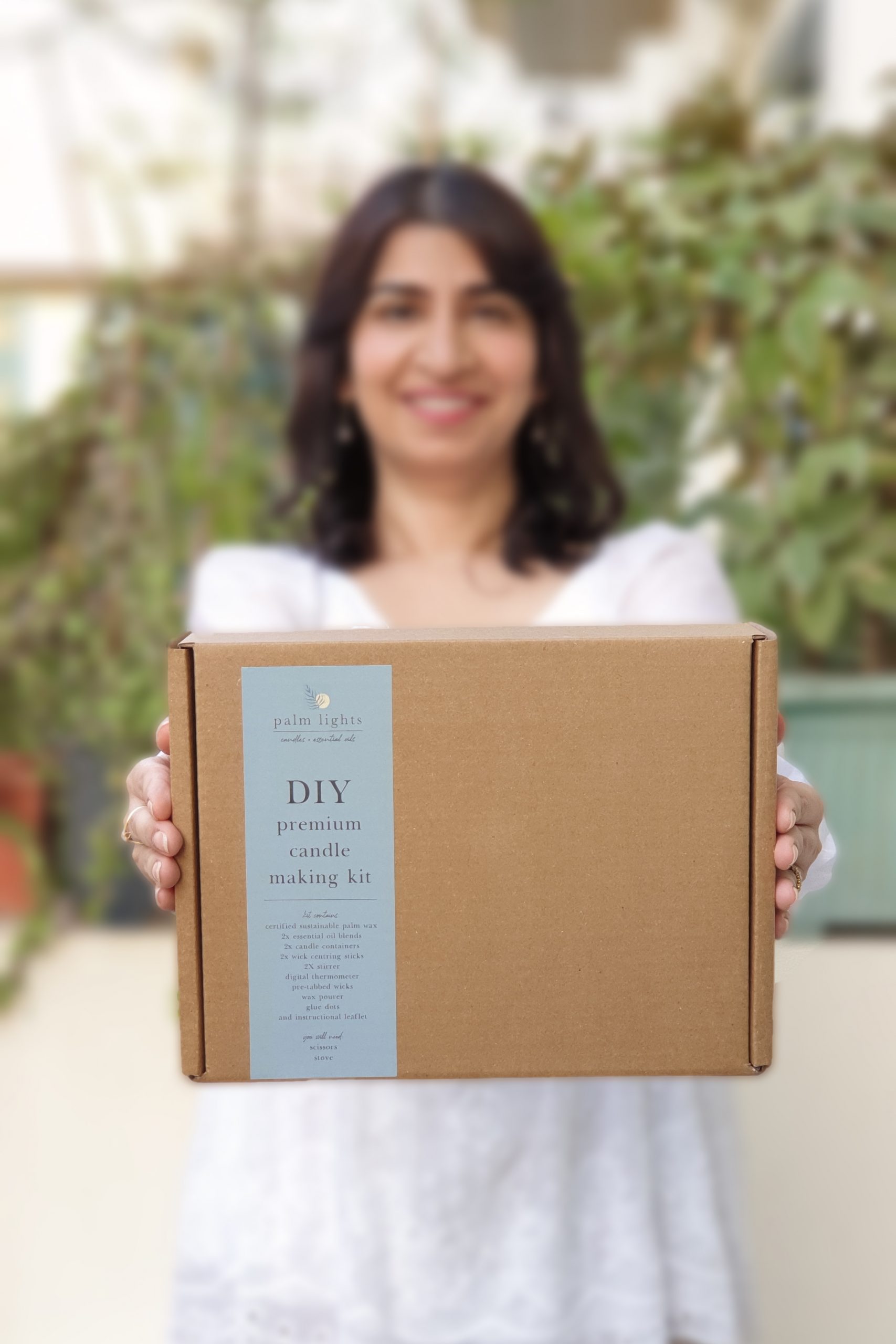 Woman holding Palm Lights DIY premium candle making kit box for handmade scented candles in UAE